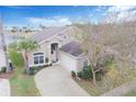 An aerial view of a charming two-story home showcasing the surrounding landscaping, driveway, and nearby pond at 252 Julliard Blvd, Davenport, FL 33897