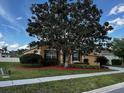 Home exterior with tidy landscaping and a lush tree providing ample shade at 2705 Treymore Dr, Orlando, FL 32825