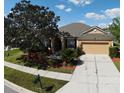 Aerial view of a one-story home with manicured lawn, mulch beds, and a two-car garage at 2705 Treymore Dr, Orlando, FL 32825