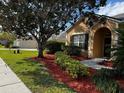 Well-maintained home featuring beautiful landscaping, mulch beds, and a manicured lawn at 2705 Treymore Dr, Orlando, FL 32825