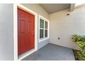 Inviting front entrance with a red door, window, and security camera at 2956 Whispering Trails Dr, Winter Haven, FL 33884