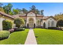 Beautiful home featuring a manicured lawn and grand double door entrance with arched windows at 401 Timberwalk Ln, Lake Mary, FL 32746