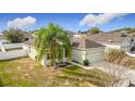 An eye-level side view of a single-story home with an attached two-car garage and a palm tree in the front yard at 673 Highland Meadows Ave, Davenport, FL 33837