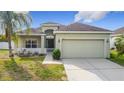 Charming single-story home with a well-manicured lawn, inviting curb appeal, and a two-car garage at 673 Highland Meadows Ave, Davenport, FL 33837