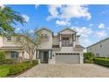 Charming two-story home with a two car garage and balcony, complemented by a brick driveway at 7483 Marker Ave, Kissimmee, FL 34747