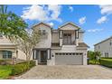 Charming two-story home with a two car garage and balcony, complemented by a brick driveway at 7483 Marker Ave, Kissimmee, FL 34747