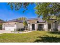 Charming single-story home boasts a well-manicured lawn, white exterior, and attached two car garage at 768 Park Valley Cir, Minneola, FL 34715