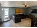 Cozy living room with tile flooring, large sectional couch, ceiling fan and a large window with wood blinds at 7834 Brockwood Cir # 2, Orlando, FL 32822