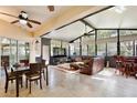 Bright sun room featuring large windows, comfortable seating, a ceiling fan, and access to the backyard at 9149 Oak Commons Way, Orlando, FL 32832