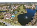 Aerial of community pool, tennis courts, lake, and water fountain in a scenic neighborhood at 13929 Fairway Island Dr # 825, Orlando, FL 32837