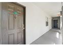 Hallway featuring unit X825 with a dark wooden door and modern knocker, leading to other units and the outside at 13929 Fairway Island Dr # 825, Orlando, FL 32837