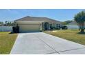 Exterior view showcasing the driveway and well-maintained front yard of the house at 1556 Lemon Ave, Winter Haven, FL 33881