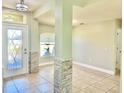 Inviting foyer with decorative glass door, tiled floor, and decorative column with stone accents at 1556 Lemon Ave, Winter Haven, FL 33881