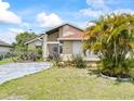 Charming single-story home with a well-maintained lawn and mature tropical landscaping at 165 Coralwood Cir, Kissimmee, FL 34743