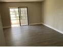 Open concept living room with wood-look floors and sliding doors to the balcony at 165 Springwood Circle # A, Longwood, FL 32750