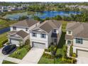 Beautiful aerial view of a two-story home with a lake in the background at 17394 Million Lakes Ct, Clermont, FL 34714
