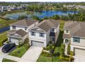 Aerial view of a two-story home with a pond in the background; highlighting its neighborhood and surrounding landscape at 17394 Million Lakes Ct, Clermont, FL 34714