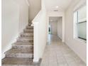 Bright entryway featuring tile flooring, a staircase, and an open view into the rest of the home at 17394 Million Lakes Ct, Clermont, FL 34714