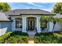 Elegant front entrance with white columns, a black front door, and vibrant green landscaping at 2106 Ridgewind Way, Windermere, FL 34786