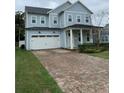 Charming two-story home featuring a brick driveway, well-manicured lawn, and cozy porch at 2108 Delaney Ave, Orlando, FL 32806