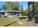 Cozy home with a screened-in porch and lush landscaping, plus an adjacent parked car at 2525 S Sanford Avenue Ave, Sanford, FL 32773