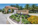 Veranda Palms entrance with manicured landscaping, signage, and a guard house under a sunny sky at 2557 Shanti Dr, Kissimmee, FL 34746