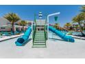 Community pool area with a water slide feature, surrounded by lounge chairs and palm trees at 2557 Shanti Dr, Kissimmee, FL 34746