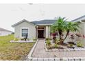 Inviting single-Gathering home with a decorative fountain, lush landscaping, and a brick pathway to the front door at 2904 Sweetspire Cir, Kissimmee, FL 34746