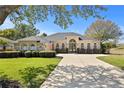 Charming home with arched windows, a long driveway, and mature landscaping at 3616 Indian Trl, Eustis, FL 32726