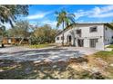 Landscaped home featuring a neutral exterior and mature trees with a paver driveway at 40140 Swift Rd, Eustis, FL 32736