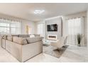 Modern living room with marble floors, a large sectional sofa, and an electric fireplace feature at 2859 Bookmark Dr, Kissimmee, FL 34746