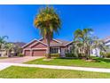 Charming single-story home featuring a manicured lawn, tropical palm trees, and a two-car garage at 4770 Cypress Forest Ln, St Cloud, FL 34772