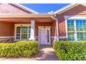 Inviting front porch with stone accents, manicured hedges, and a stylish white front door at 4770 Cypress Forest Ln, St Cloud, FL 34772