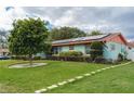 Landscaped front lawn of a home featuring a healthy tree, bushes, and solar panels on the roof at 4792 Indian Gap Dr, Orlando, FL 32812