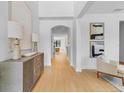 Hallway view with an arched opening, a lovely hall table with lamps, and hardwood floors at 5116 Sorrento W Blvd, St Cloud, FL 34771