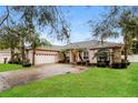 Beautiful one-story house boasts a two car garage, lush green lawn and attractive palm tree landscaping at 5543 Grey Hawk Ln, Lakeland, FL 33810