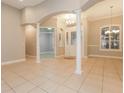 Inviting foyer features tiled flooring, white columns, and a decorative chandelier above a glass-paneled front door at 5543 Grey Hawk Ln, Lakeland, FL 33810