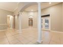 Spacious living room featuring tiled flooring, elegant columns, and a bright patio entrance at 5543 Grey Hawk Ln, Lakeland, FL 33810