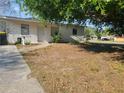 A simple one-story house with a plain front yard covered in leaves at 598 E Highland Ave, Clermont, FL 34711