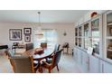 Formal dining area with stylish chandelier, dark wood table with leather chairs, and decorative display cabinets at 607 Black Eagle Dr, Groveland, FL 34736