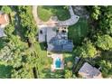 An aerial view of the property, showing the pool, lush landscaping, and circular driveway at 6115 Linneal Beach Dr, Apopka, FL 32703