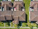 Aerial view of townhomes with brown roofs, green grass, and a cozy patio with a red umbrella at 9024 Savannah Magnolia Ln, Orlando, FL 32832