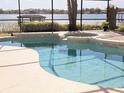 Inviting swimming pool and spa with serene lake backdrop and screened enclosure at 9137 Southern Breeze Dr, Orlando, FL 32836