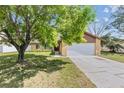 Attractive home with a lush front yard, mature tree, and attached garage, offering a welcoming curb appeal at 1045 Dishman Loop, Oviedo, FL 32765