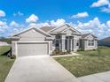 Attractive single-story home with a stone-accented front, manicured lawn, and an attached two-car garage at 1113 Caloosa Ridge Way, Babson Park, FL 33827