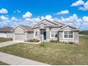 Inviting single-story home boasts a stone-accented facade, lush lawn, and an attached two-car garage at 1113 Caloosa Ridge Way, Babson Park, FL 33827