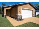 Home's exterior featuring a two-car garage, stone accents, fresh paint, new driveway and manicured landscaping at 1508 W 16Th St, Sanford, FL 32771
