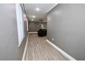 Hallway with new, light colored, wood-look flooring, light gray walls, white trim and baseboards and recessed lighting at 1508 W 16Th St, Sanford, FL 32771