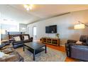 Cozy living room features hardwood floors, a ceiling fan, and ample seating with couches and a TV at 15733 Switch Cane St, Clermont, FL 34711