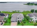 Aerial view of a two-story home with a gray tile roof on a lake at 16689 Broadwater Ave, Winter Garden, FL 34787